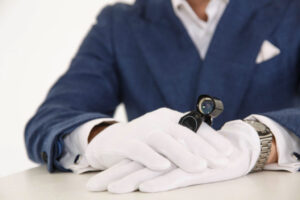 Man in blue dress shirt holding black and silver round analog wa