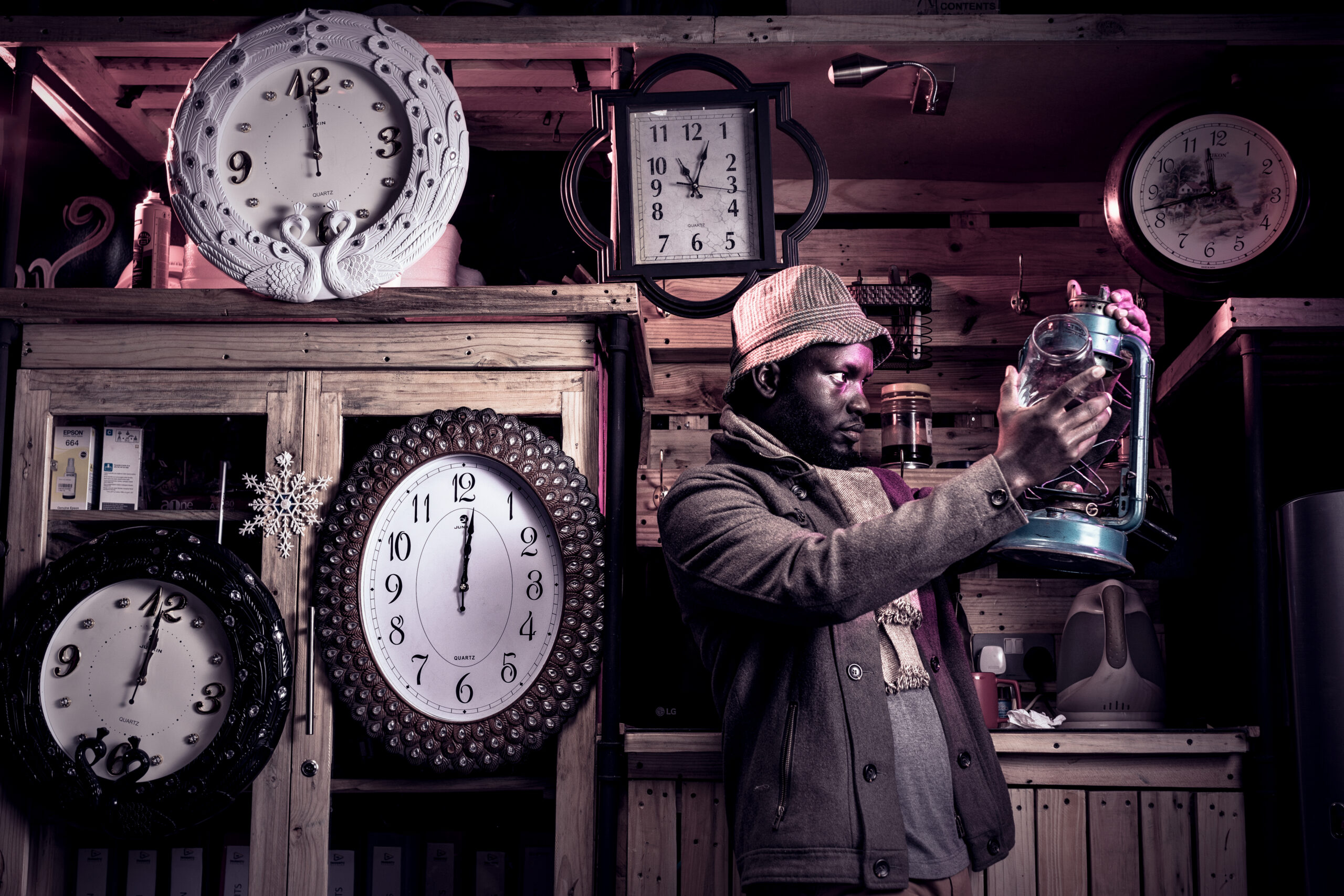A man wearing a black jacket and hat holding a clear drinking gl