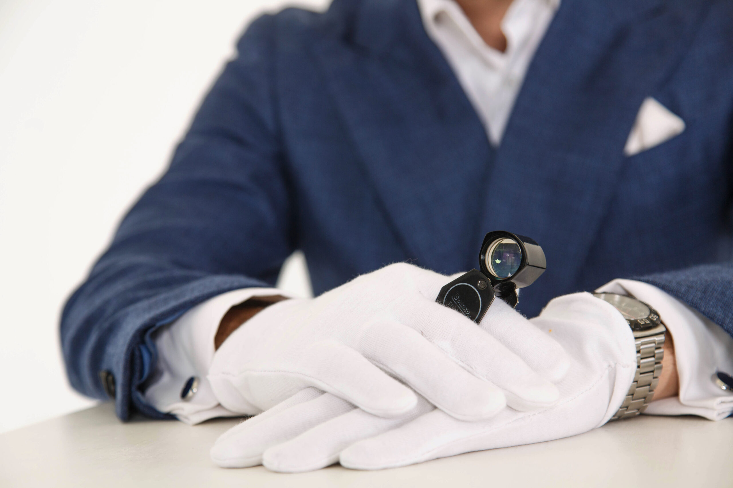 Man in blue dress shirt holding black and silver round analog wa