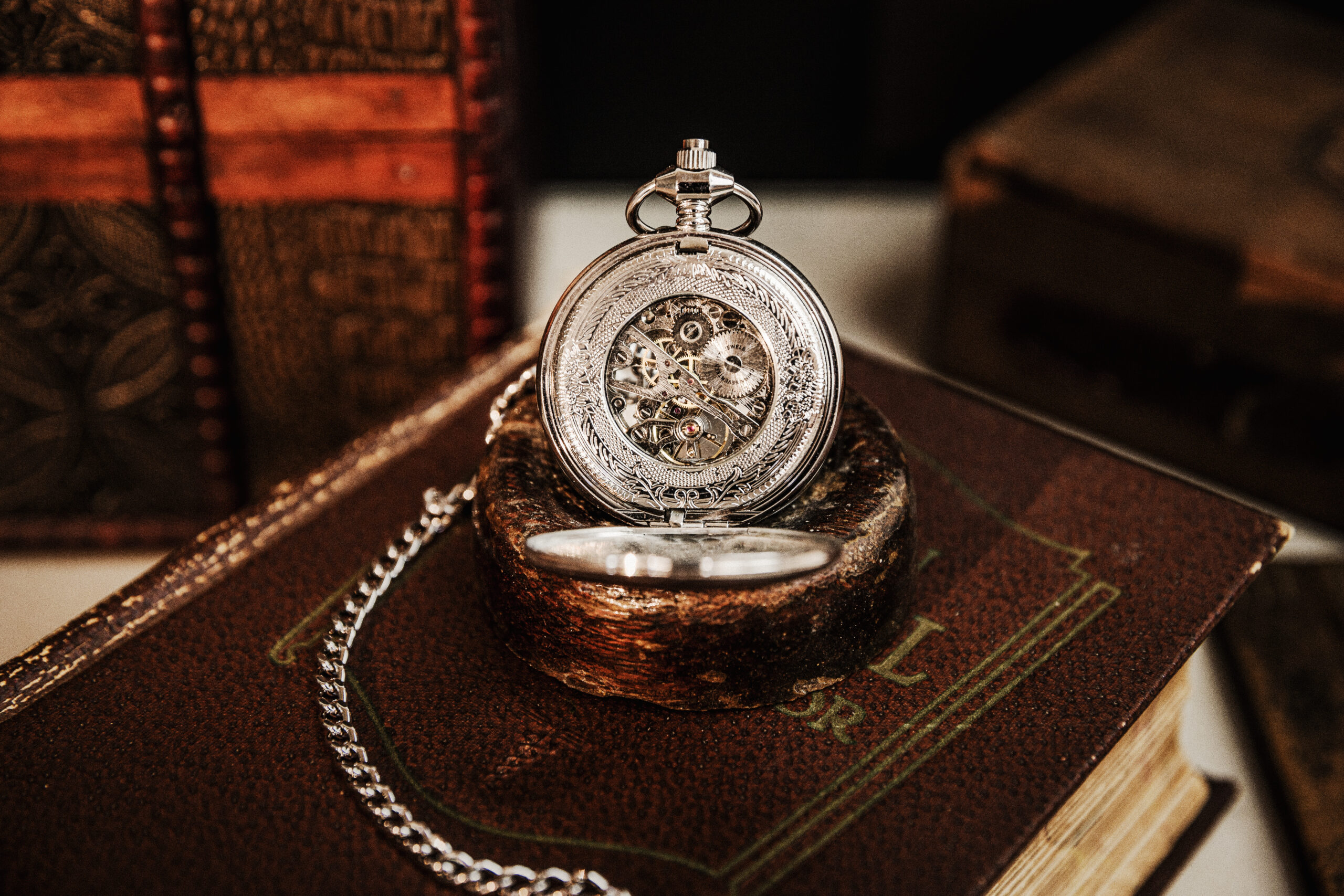 Silver and gold pocket watch on brown wooden table
