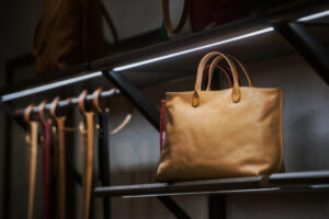 Brown leather handbag on black metal rack